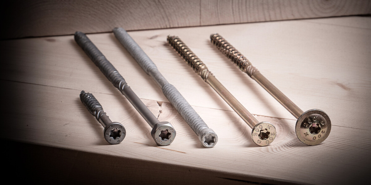Solid-Drive Fünf Solid Wood-Schrauben liegen nebeneinander auf einer Fläche aus Holz, die Köpfe zum Betrachter gedreht.