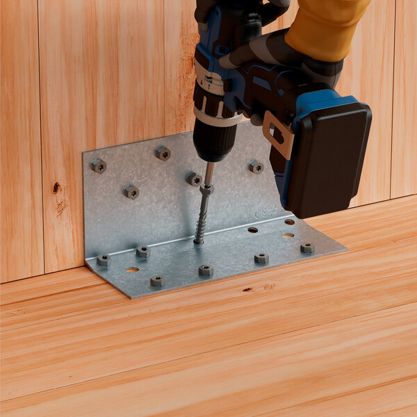 Ein blauer Akkuschrauber dreht eine Schraube in einen stählernen Winkel, der zwei Holzplatten miteinander verbindet. Die Hände, die den Schrauber halten, stecken in schwarzen Handschuhen, die bis zum Handgelenk reichen - ein Teil eines nackten Armes ist zu sehen.