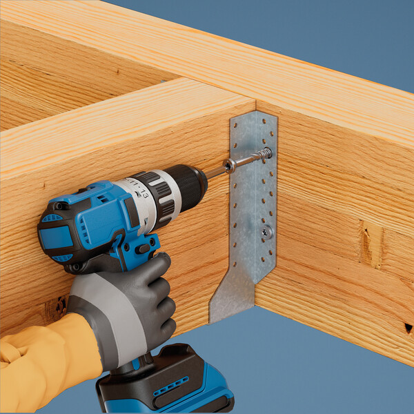 Ein blauer Akkuschrauber kommt von links und dreht eine Schraube in einen Balkenschuh ein, der zwei hölzerne Balken miteinander verbindet. Der Hintergrund ist blau. Die Hand, die den Akkuschrauber hält, steckt in einem schwarz-grauen Handschuh, der bis zum Handgelenk reicht.