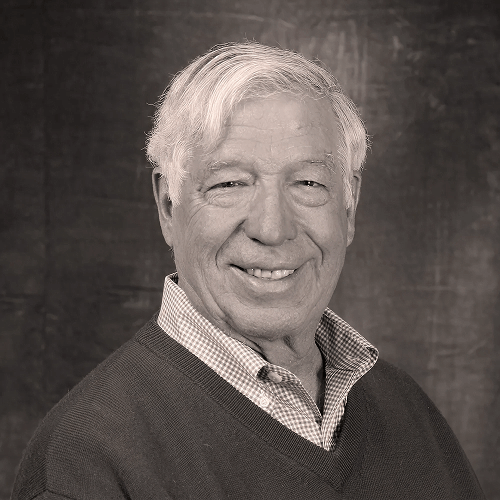 Präsident Tom Fitzmeyers auf einem Schwarzweiß-Foto als Porträt. Er lächelt in die Kamera.