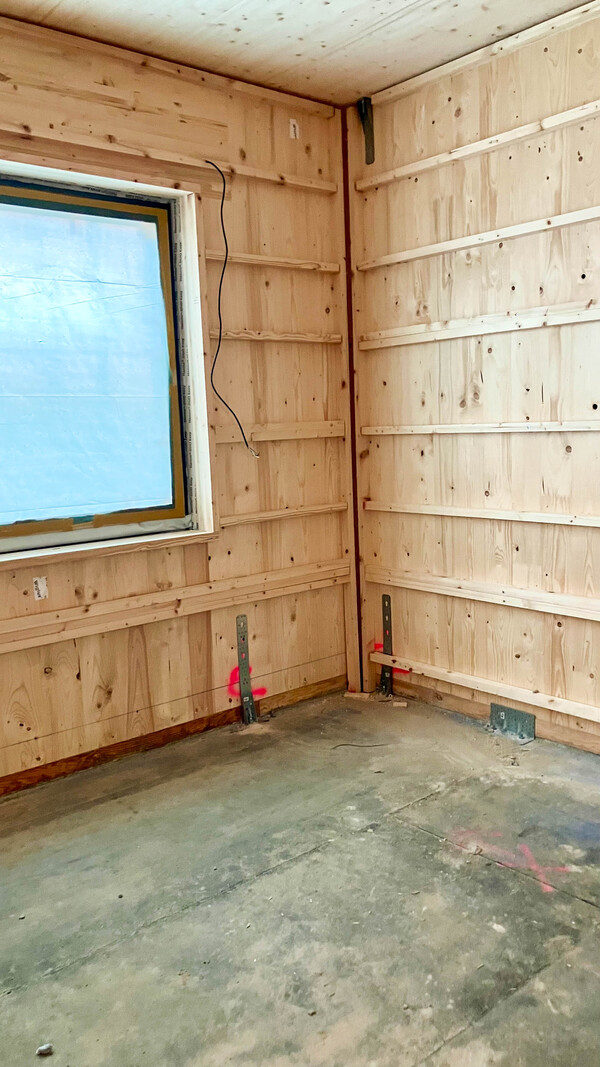 CLT Wände und Decken mit Fenster. Verbindungsmittel auf dem Boden zu sehen.