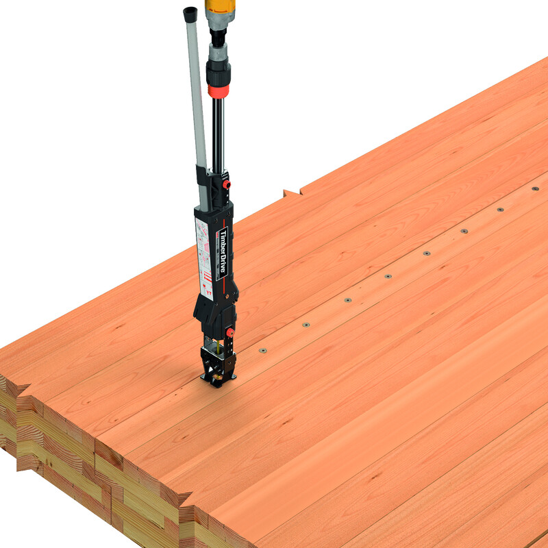 Eine dicke, mehrschichtige Holzplatte (Brettsperrholz) von rotbrauner Farbe, diagonal, füllt fast zwei Drittel des Bildes aus. Ein Timber Drive, aufrecht stehend und von oben links kommend, setzt mit dem flachen Ansatz ans Holz an, um eine Schraube einzudrehen. Hinter dem Gerät, nach oben rechts führend, ist bereits eine gleichmäßige Reihe von Schrauben ins Holz eingedreht.