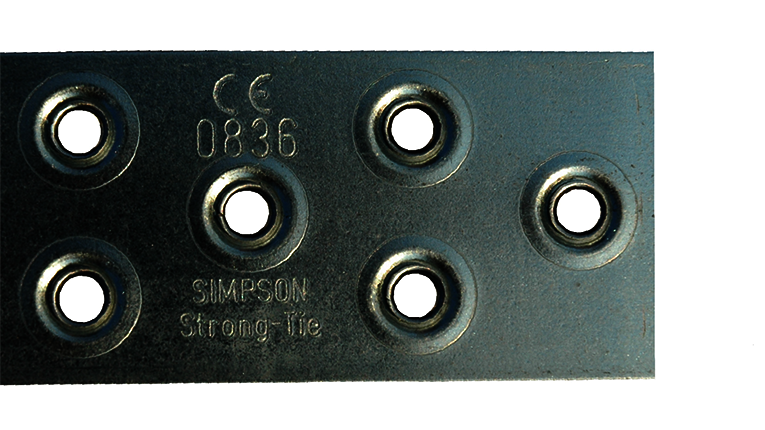Die Nahaufnahme eines BAN094050-Windrispenbandes von Simpson Strong-Tie. Zu sehen sind sechs Löcher (für Nägel), und die starke Wölbung des Materials um die Löcher herum ist deutlich zu erkennen.