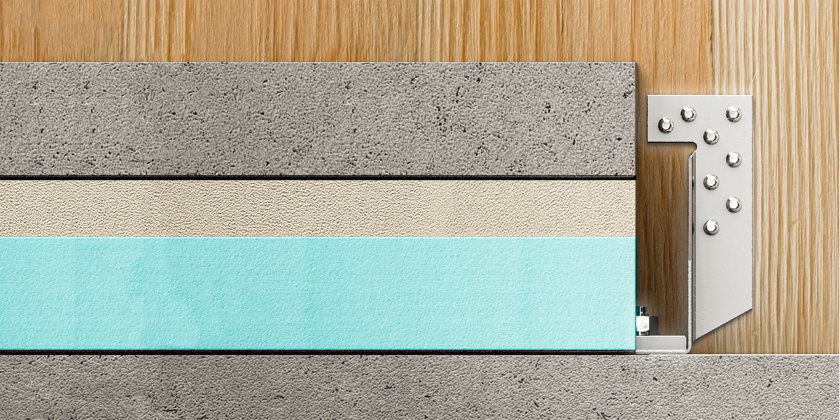 Ein Holzverbinder ist direkt von vorne zu sehen, allerdings nur zur Hälfte: Die andere Hälfte wird von einem Querschnitt verschiedener Fußbodenmaterialien verdeckt - Dämmstoff, Estrich etc. Der Verbinder sitzt auf einem Boden aus Beton und hält eine Wand aus Holz.